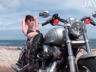 Sexy bikini-clad biker babe pours in the curves.